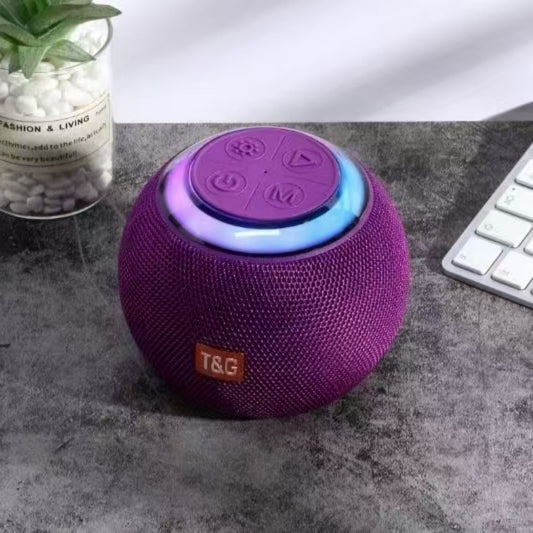 T&G TG683 Mini Portable Bluetooth Speaker with LED Light in purple, placed beside a keyboard, delivering portable audio with vibrant LED lighting.