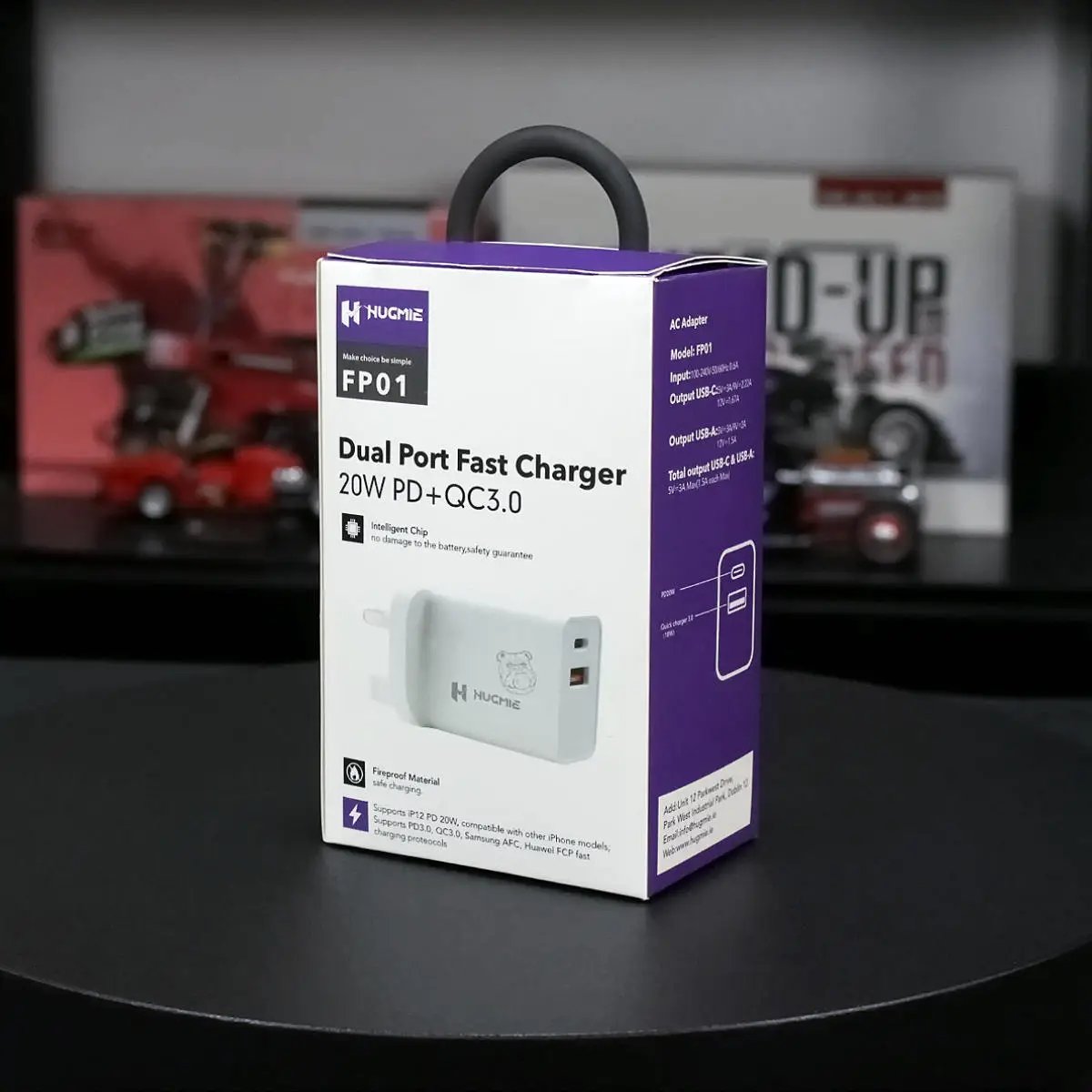 Hugmie FP01 dual port fast charger in its retail packaging, highlighting PD 20W and QC3.0 technology for rapid charging.