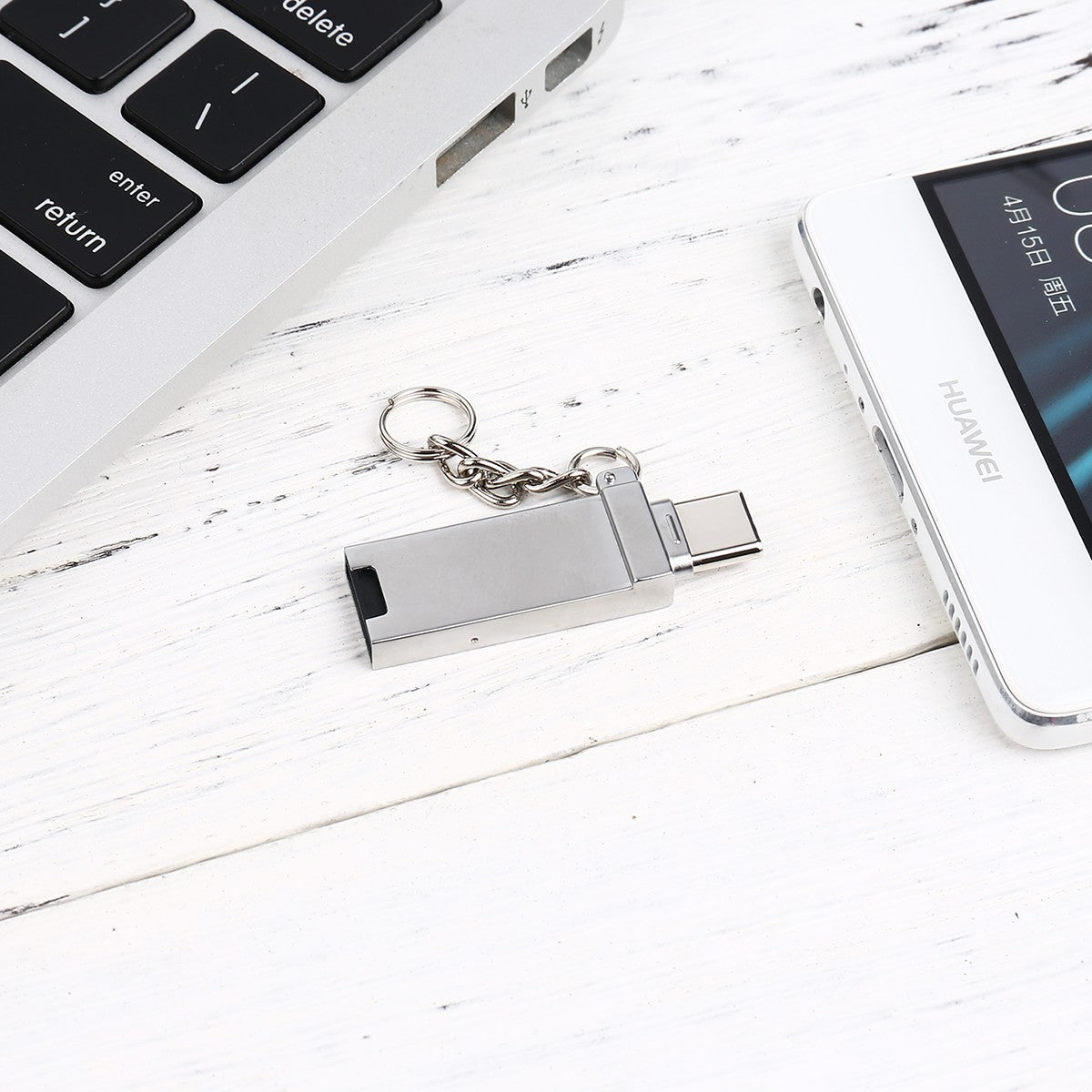 FT-ADA21 2-in-1 Card Reader for Type-C & USB A placed between laptop and smartphone, highlighting its compact and mobile-friendly design | Hugmie