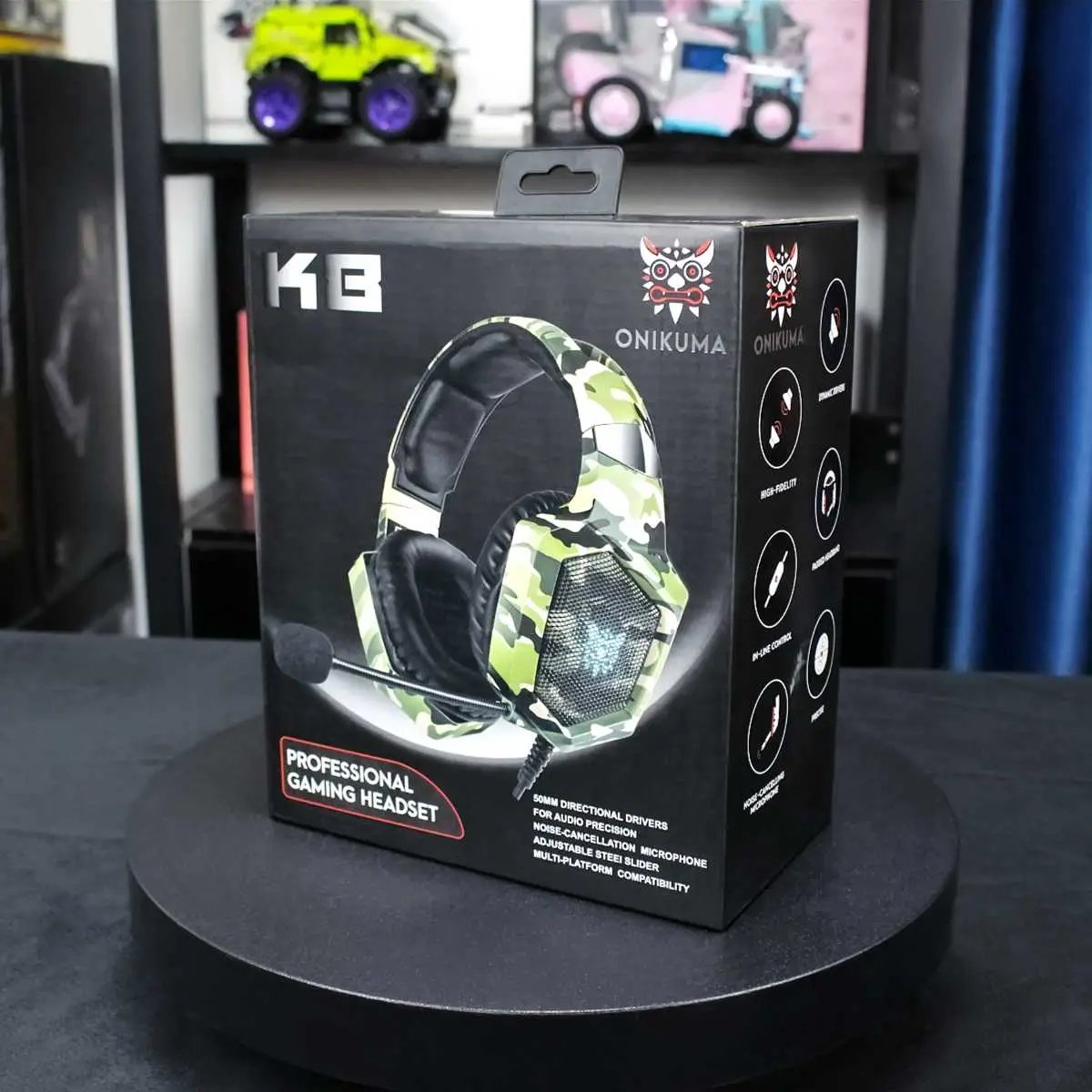 ONIKUMA K8 Wired Gaming Headphones packaging in green camouflage design. Showcases key features such as noise-canceling mic and immersive sound.