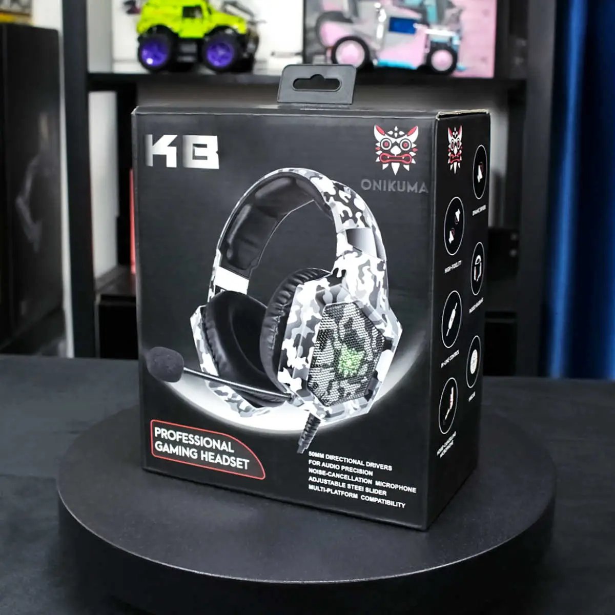 ONIKUMA K8 Wired Gaming Headphones packaging in white camouflage design. Highlights compatibility, LED lighting, and noise-canceling microphone.