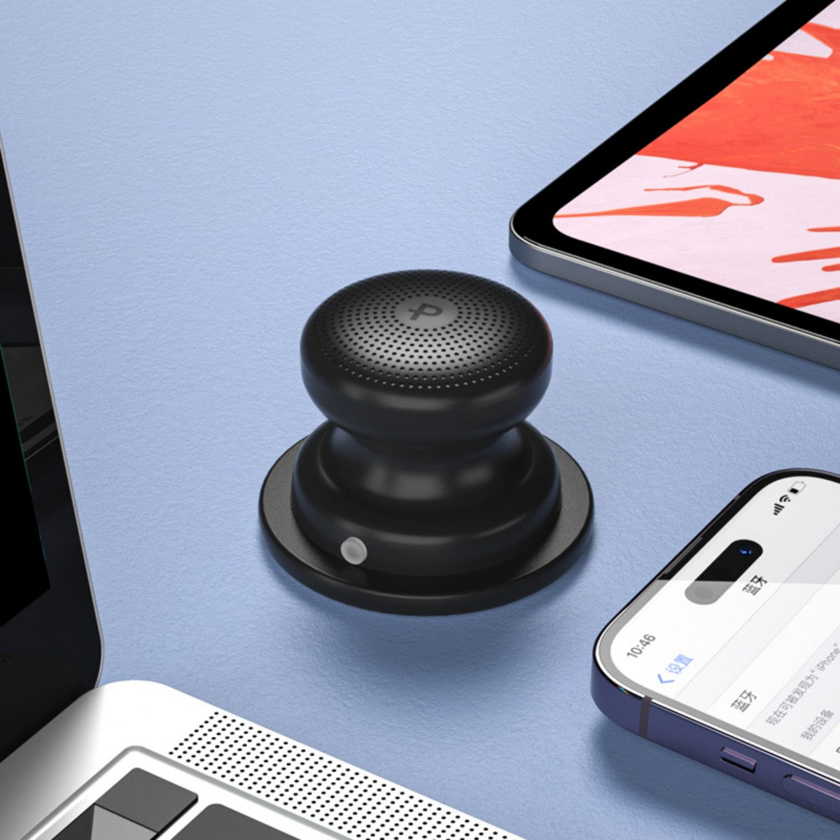 Black EWA A117 Portable Mini Bluetooth Speaker placed beside a laptop and smartphone, emphasizing its desktop compatibility.