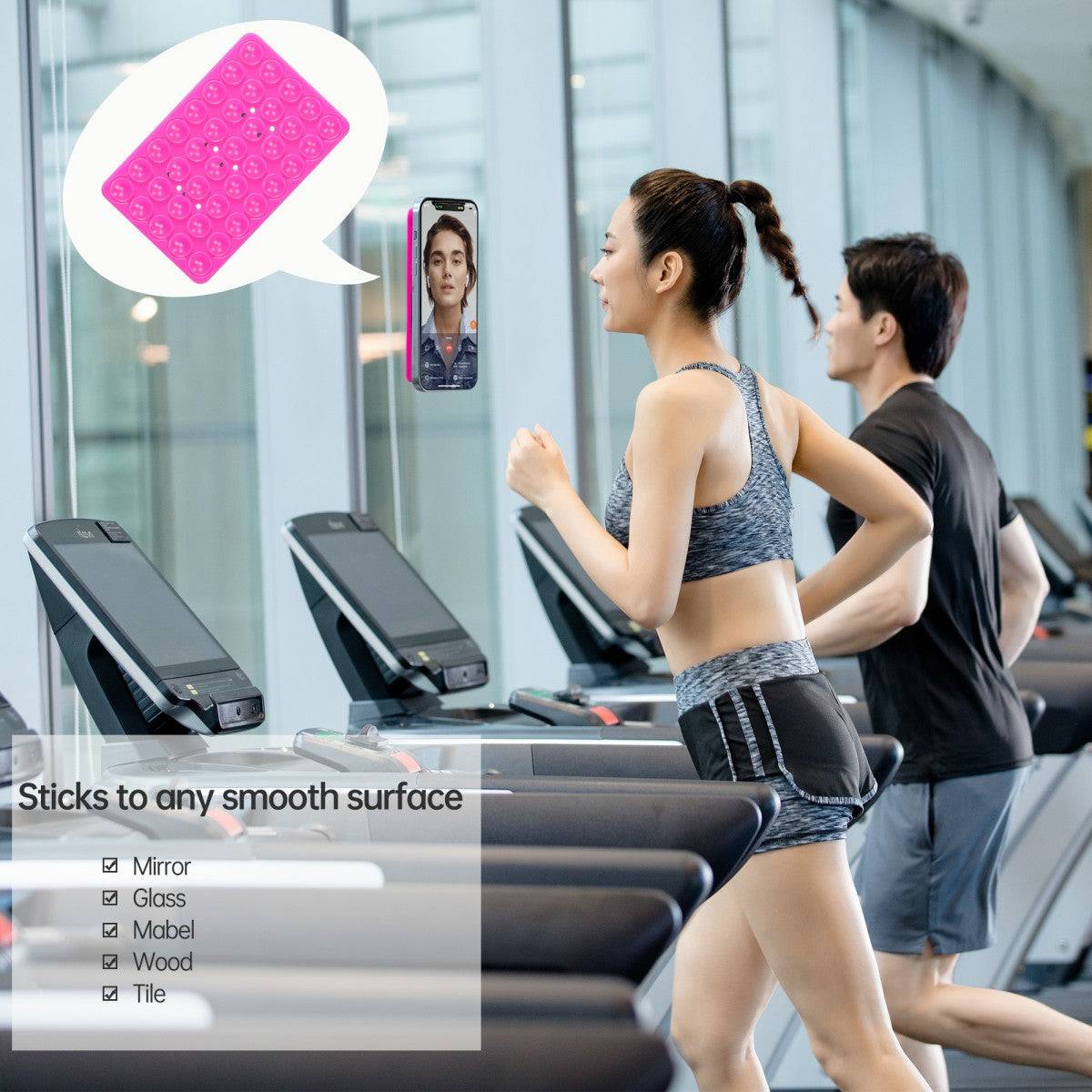 Pink silicone suction cup phone holder attached to a treadmill, demonstrating its strong adhesion on smooth surfaces like glass and tile.