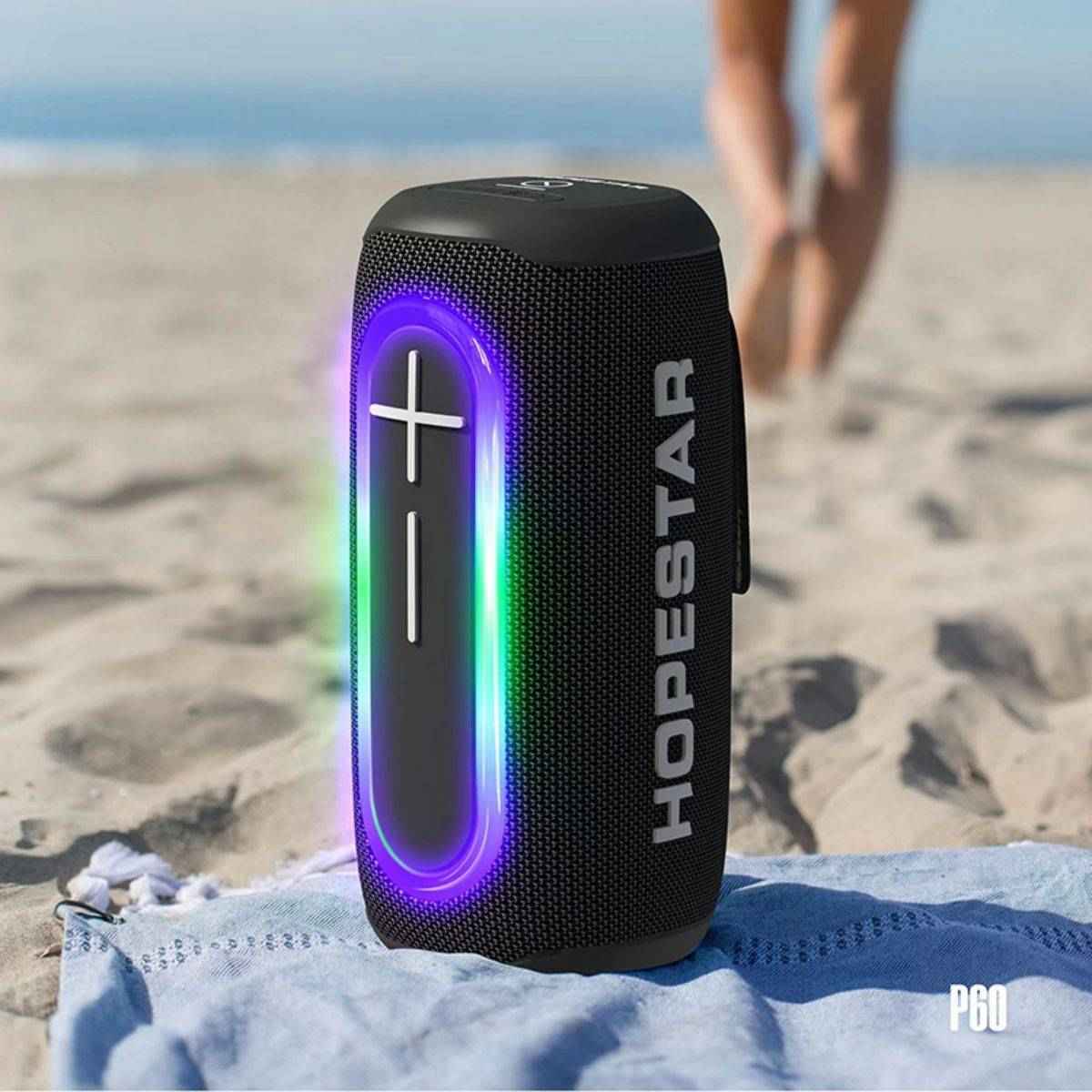 Hopestar P60 Waterproof Bluetooth Speaker on a beach towel, perfect for outdoor and beachside music enjoyment.