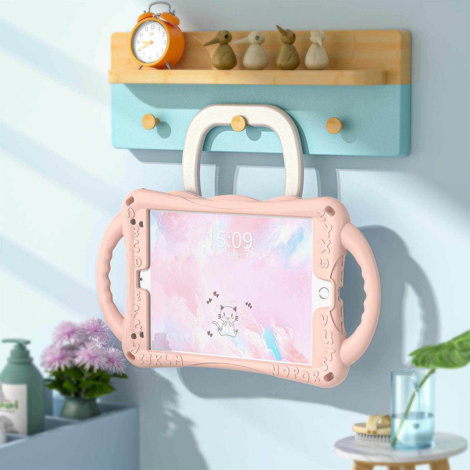 Pink kitten iPad Mini protective case hanging on a wall hook, demonstrating its foldable handle and space-saving storage capability.