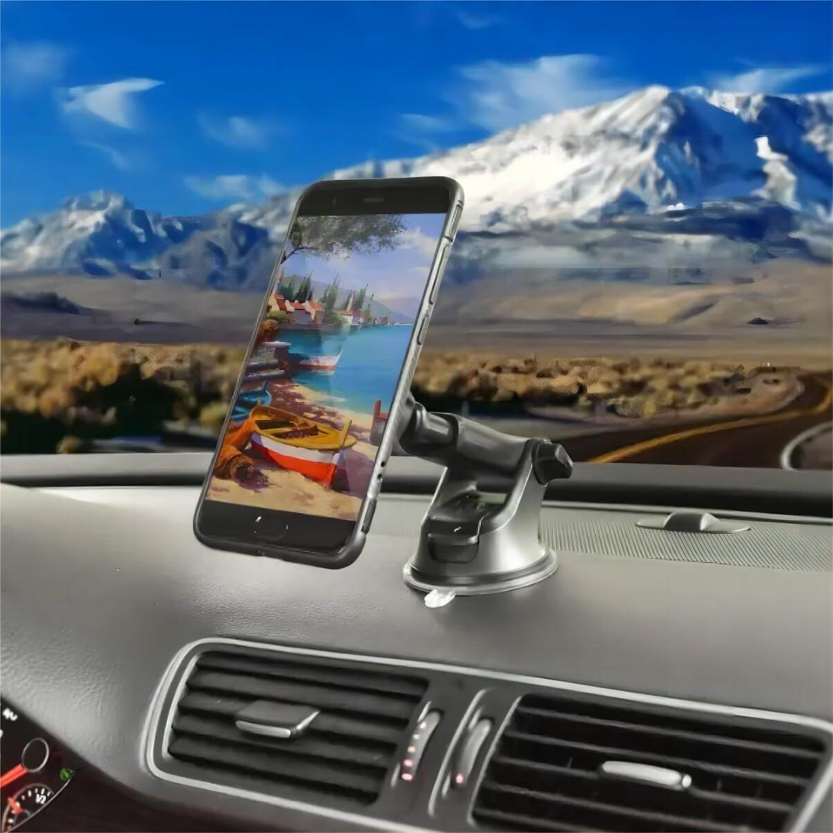Magnetic car phone holder securely holding a smartphone on a dashboard with a scenic background.